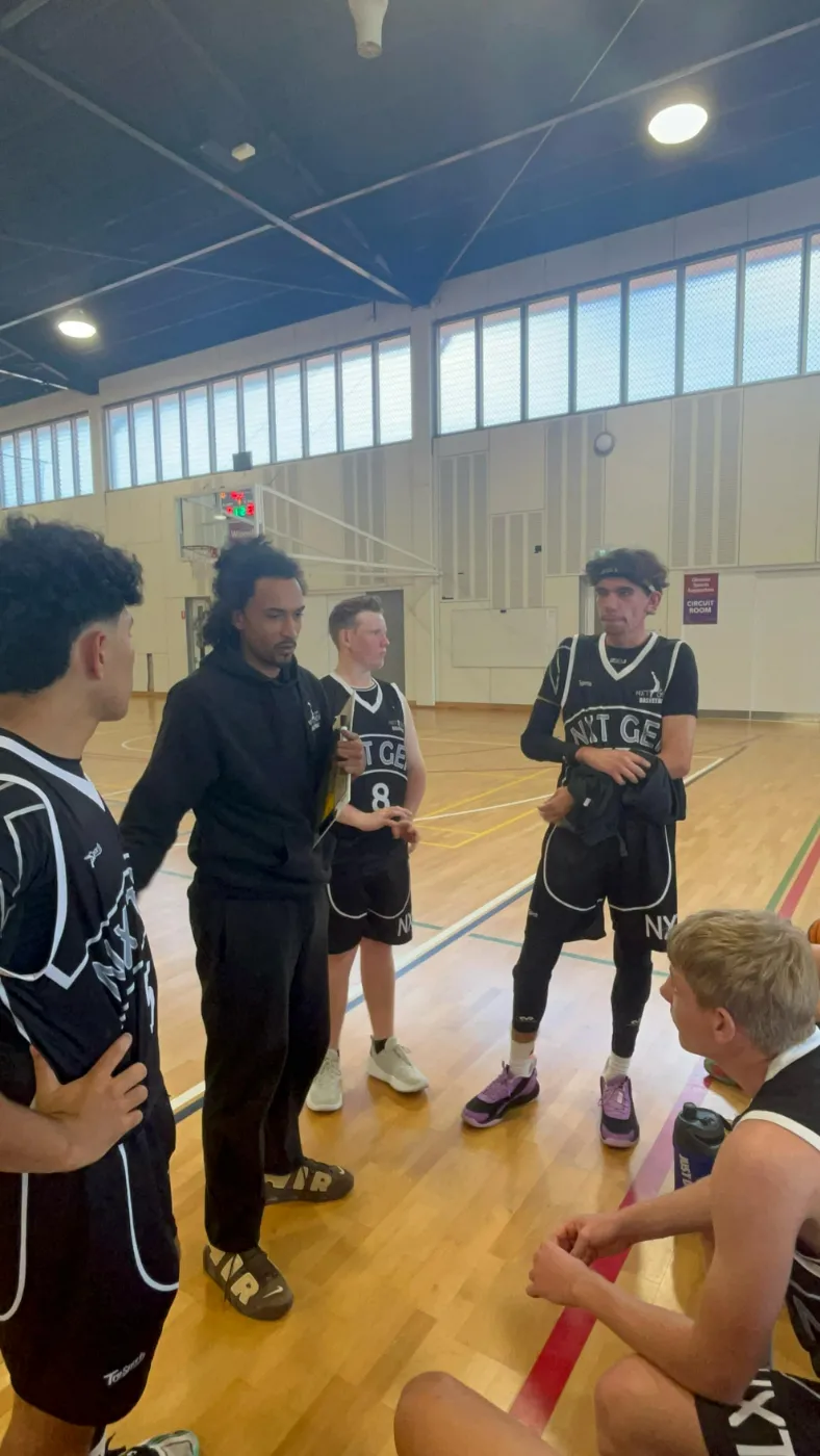 A basketball team listening to their coach during a game