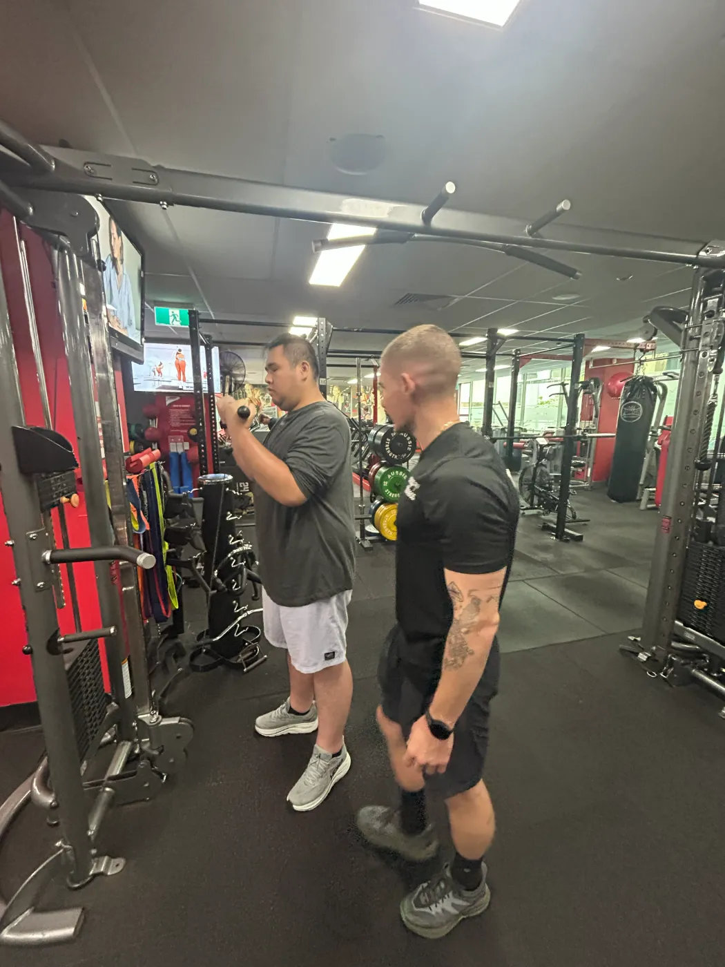 A participant working on strength goals with a fitness trainer