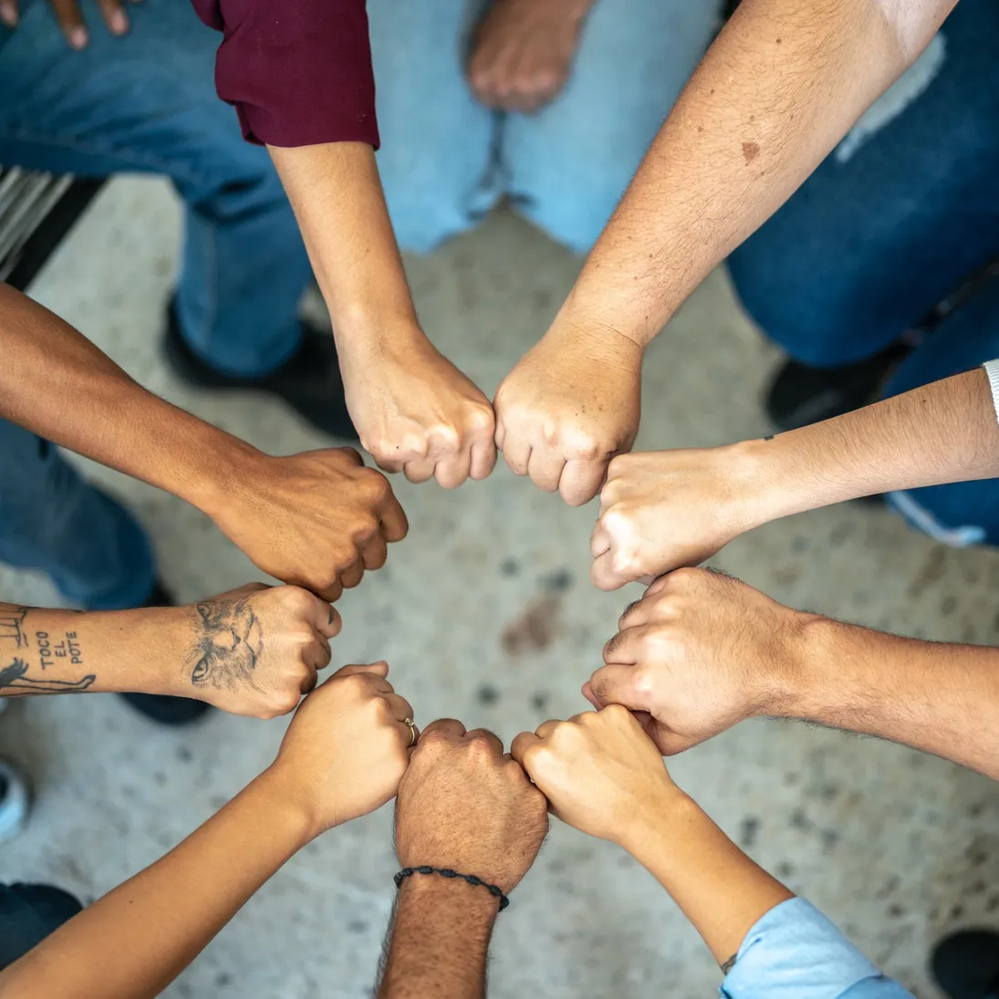 A diverse group of people joining hands in a circle