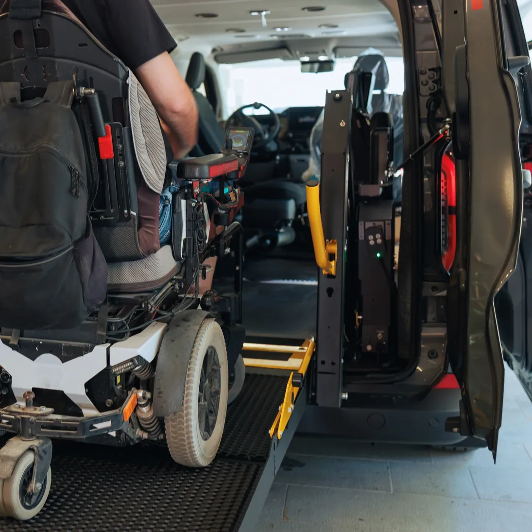 A wheelchair user boarding an accessible vehicle via a ramp