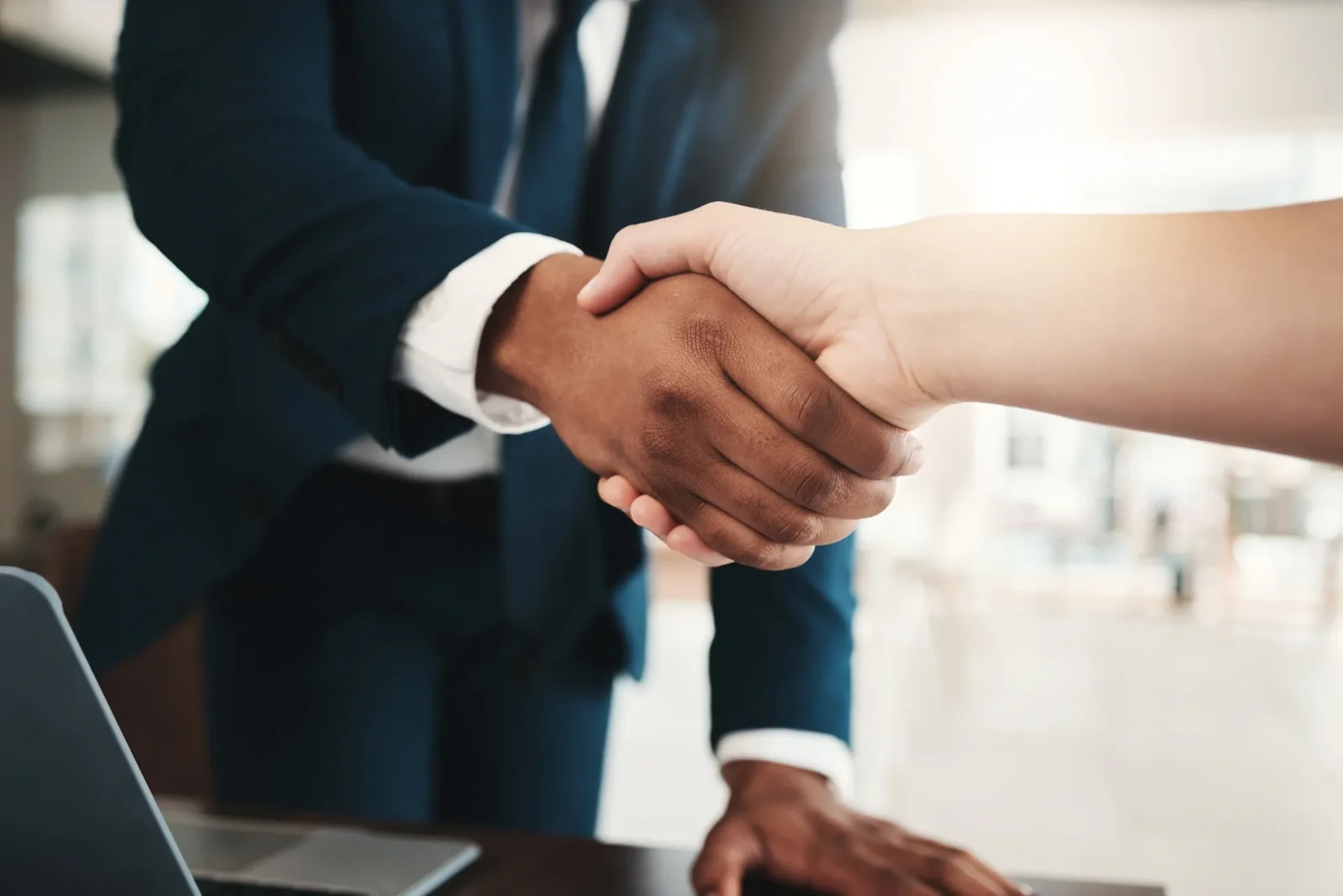 Two people shaking hands in welcome